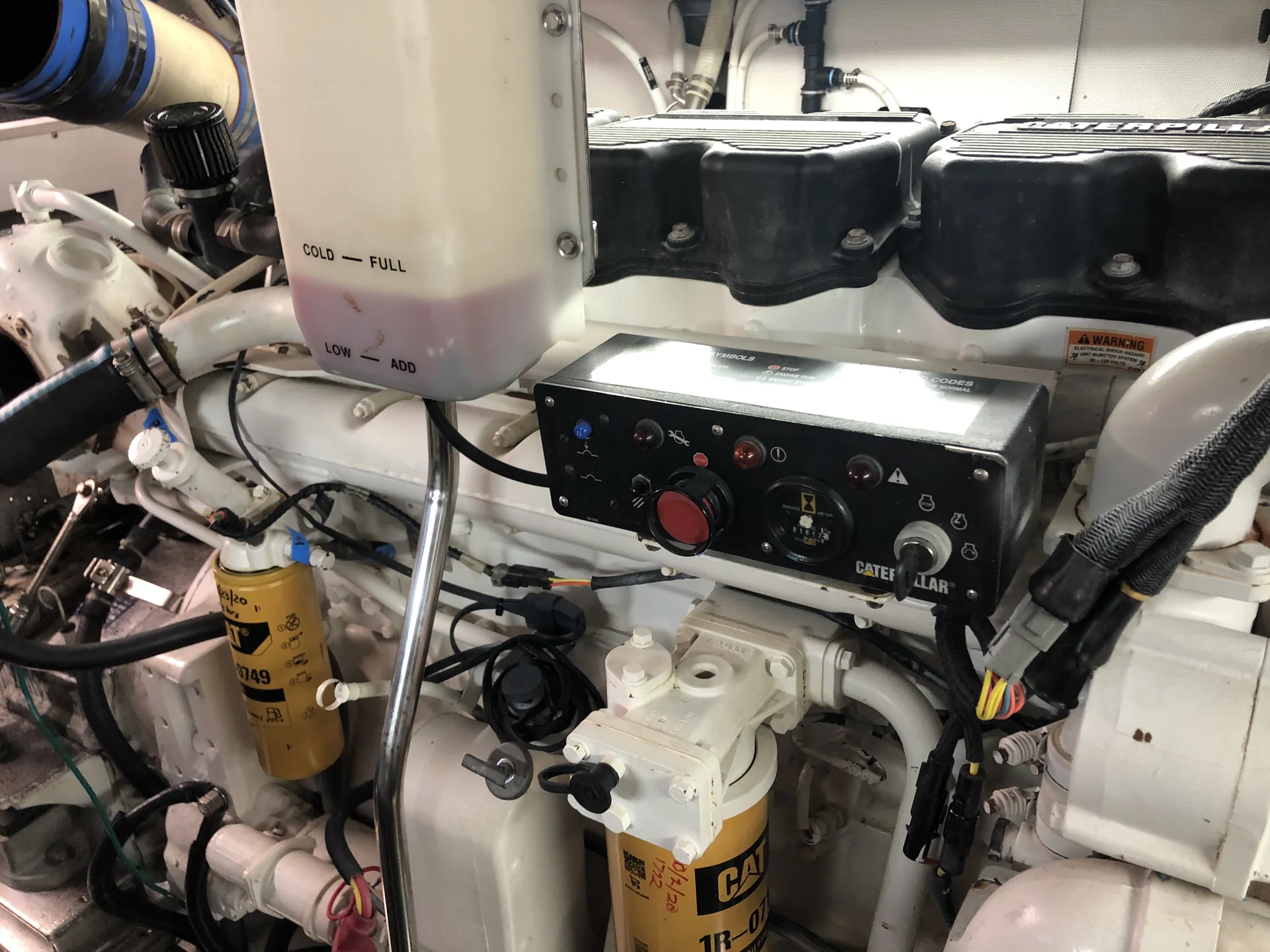 Caterpillar marine diesel engine with filters, plumbing, and controls in an engine room